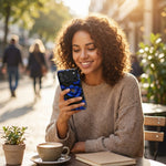 Smiling woman holding smartphone with blue floral case, size variant shown, sitting outdoors with coffee