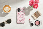 Flat lay with pink rose phone case and accessories
