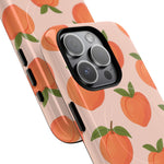 Close-up of overlapping peach-pattern cases with square triple-camera opening #iphone-15-pro