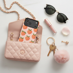 Peach-pattern wide-camera case in a pink quilted handbag beside sunglasses and keys #iphone-18-pro