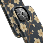 Close-up of overlapping navy cherry-blossom cases with square triple-camera opening and side controls #iphone-14-pro-max