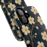 Close-up of overlapping navy cherry-blossom cases with vertical dual-camera opening and side controls #iphone-16-plus