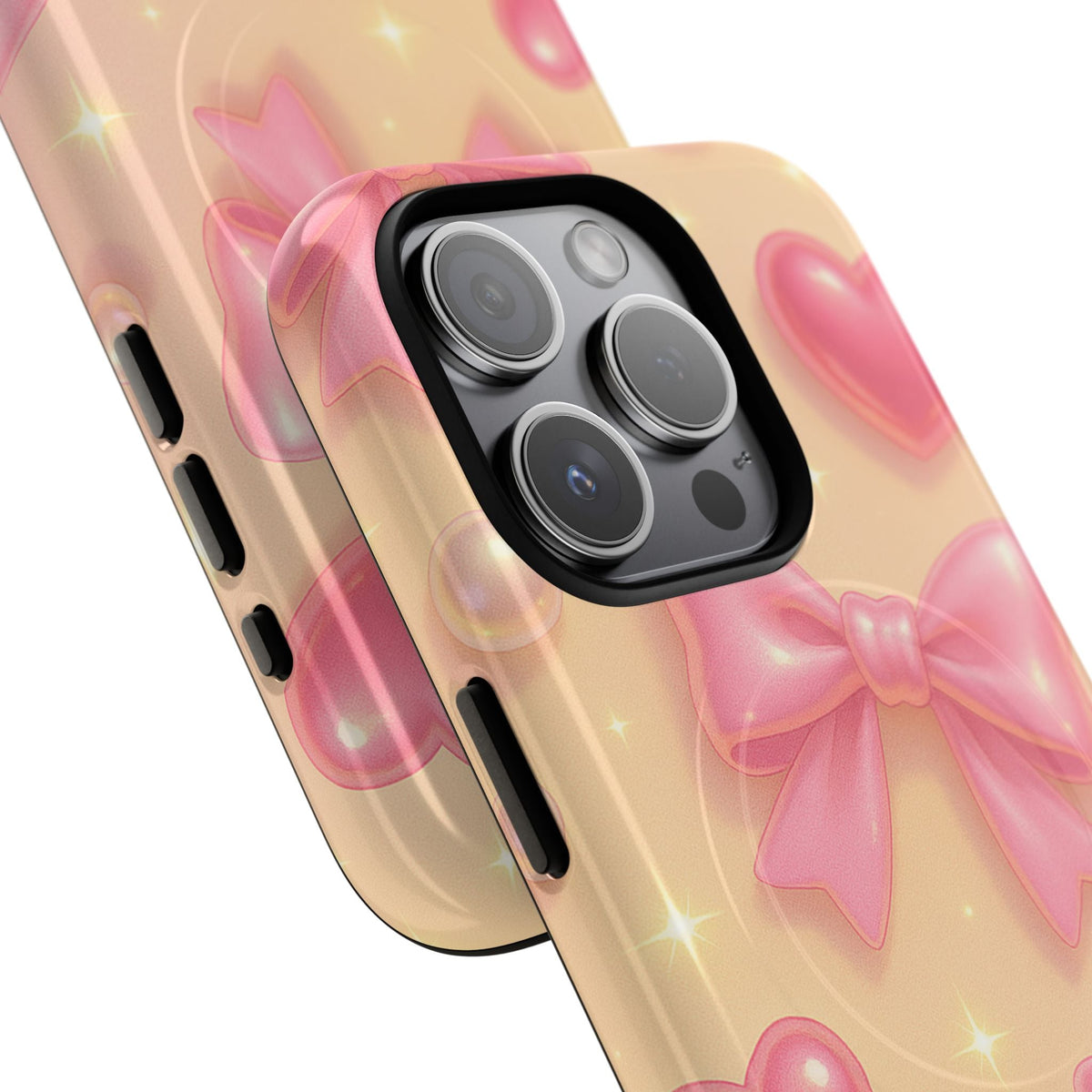 Close-up of overlapping pink bow-and-heart Coquette Sparkle cases with square triple-camera opening and side controls #iphone-14-pro-max