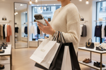 Person holding a white silk-and-gold wide-camera case with shopping bags in a store #iphone-17-pro-max