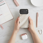 White silk-and-gold wide-camera case held beside a planner, pen and earbuds #iphone-17-pro-max