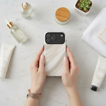 White silk-and-gold wide-camera case held among skincare and cosmetics #iphone-17-pro