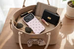 Cherry-pattern pink case in an open handbag with everyday essentials #iphone-17-pro