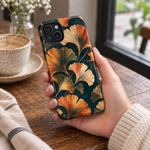 Adult woman holding the Nocturne Ginkgo case at a cafe #iphone-13