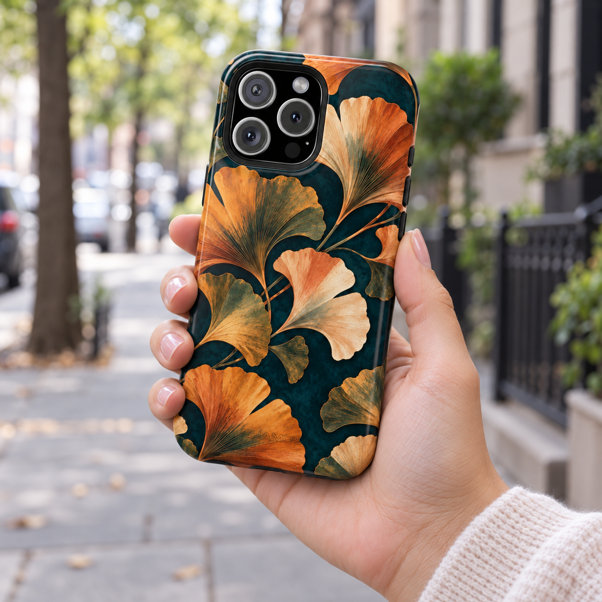 Adult woman holding the Nocturne Ginkgo case outdoors #iphone-15-pro