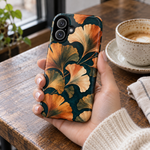 Adult woman holding the Nocturne Ginkgo case at a cafe #iphone-17