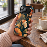 Adult woman holding the Nocturne Ginkgo case at a cafe #iphone-17-pro-max