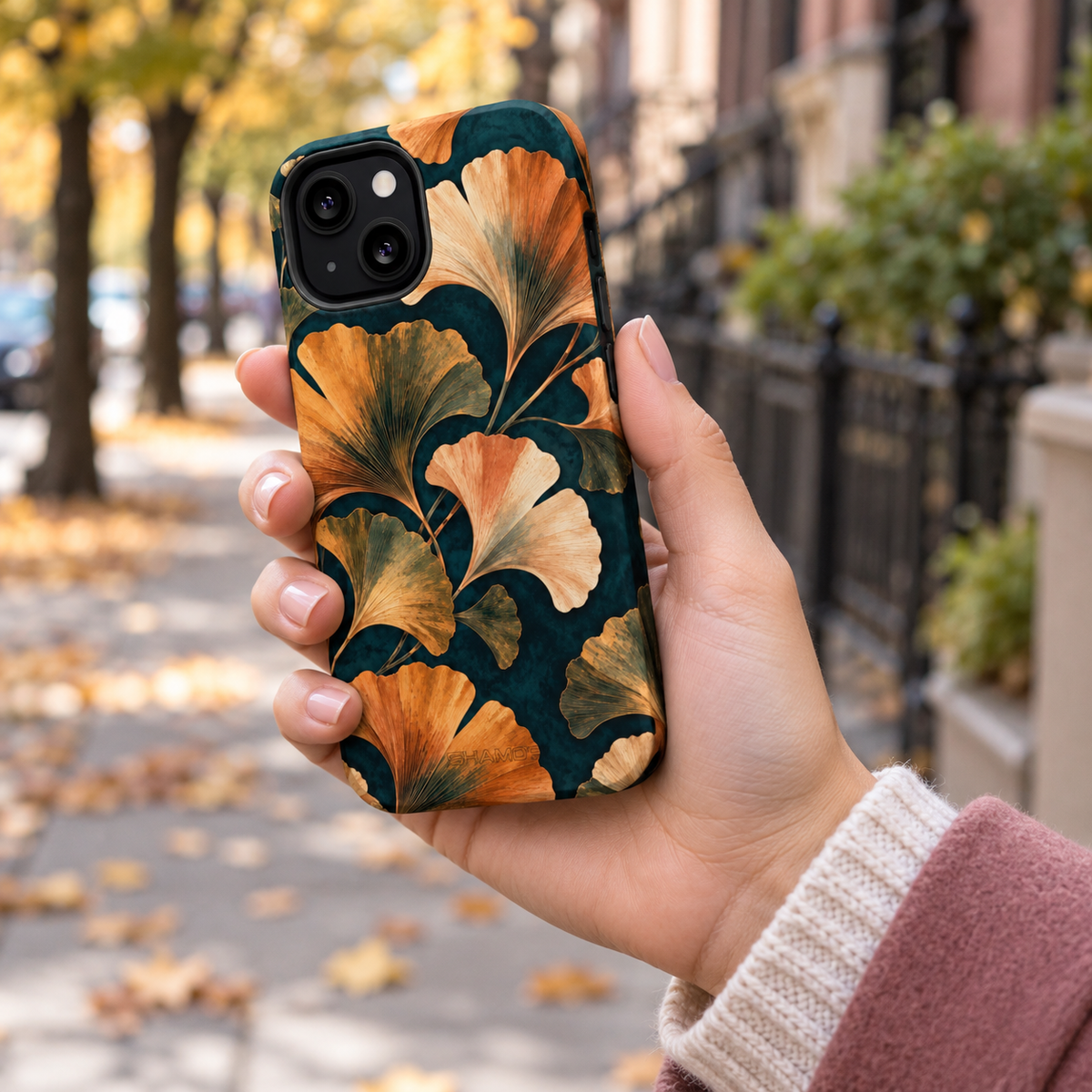 Adult woman holding the Nocturne Ginkgo iPhone 13 case outdoors #iphone-13