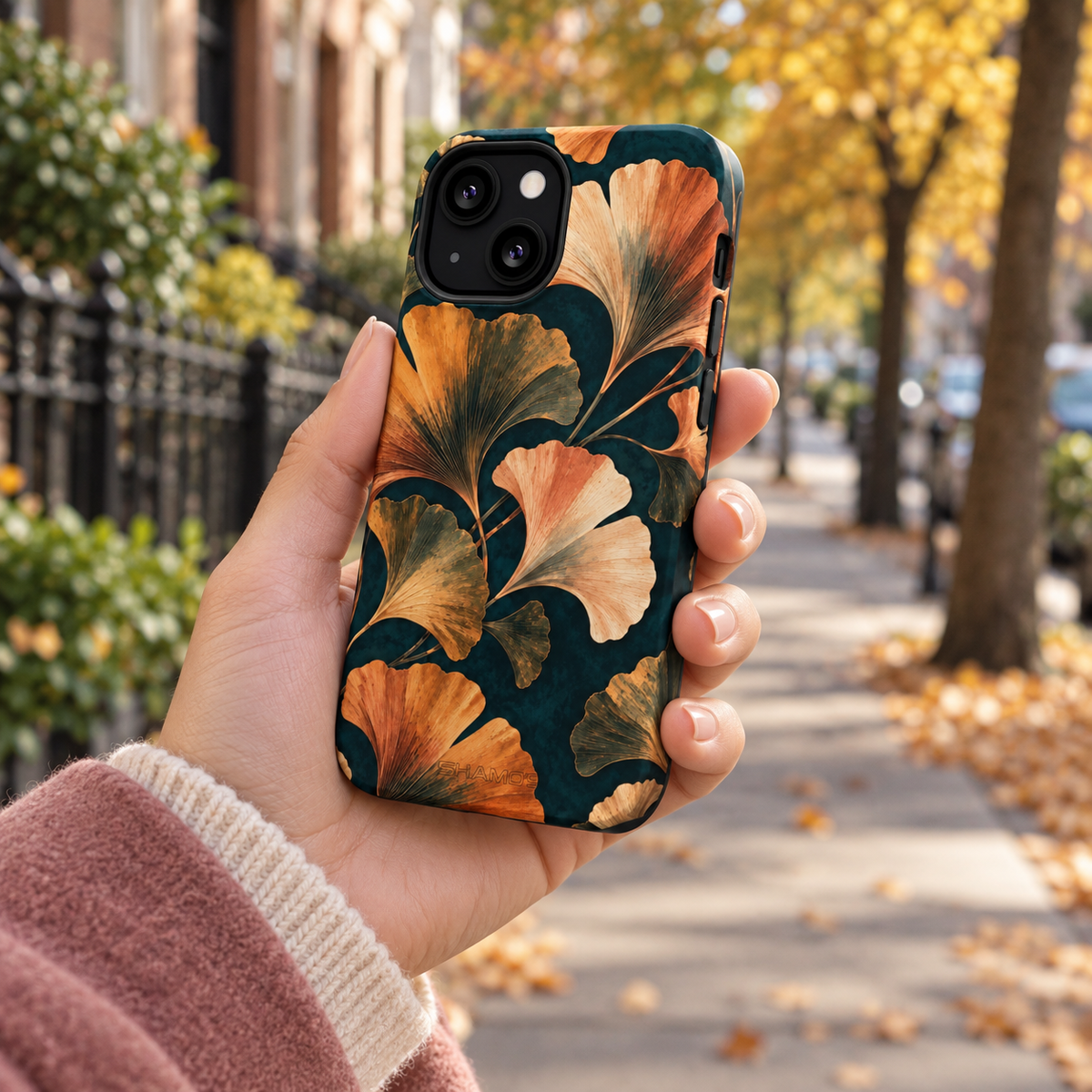 Adult woman holding the Nocturne Ginkgo iPhone 13 Mini case outdoors #iphone-13-mini