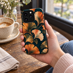 Adult woman holding the Nocturne Ginkgo iPhone 13 Pro case at a cafe #iphone-13-pro