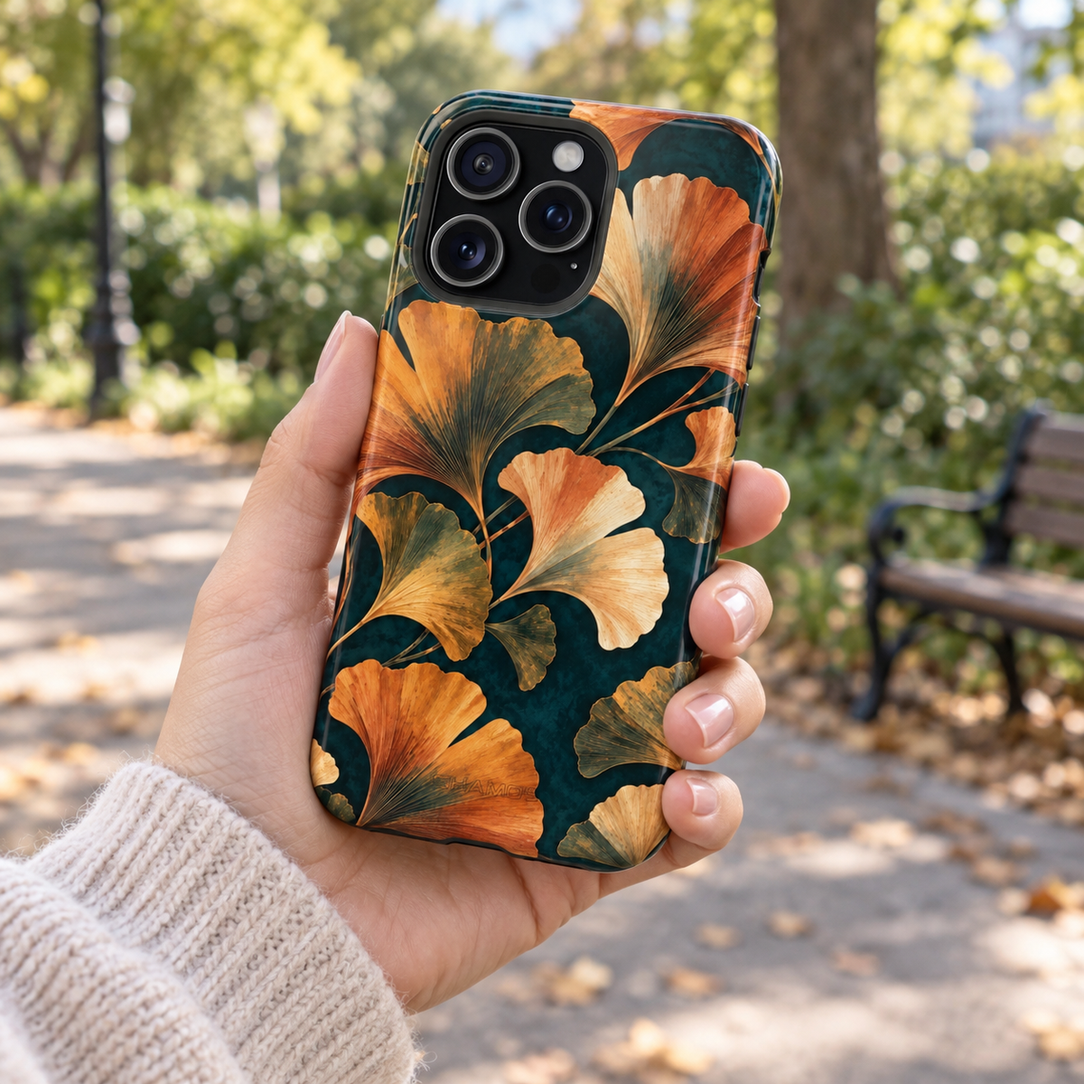 Adult woman holding the Nocturne Ginkgo iPhone 15 Pro Max case outdoors #iphone-15-pro-max