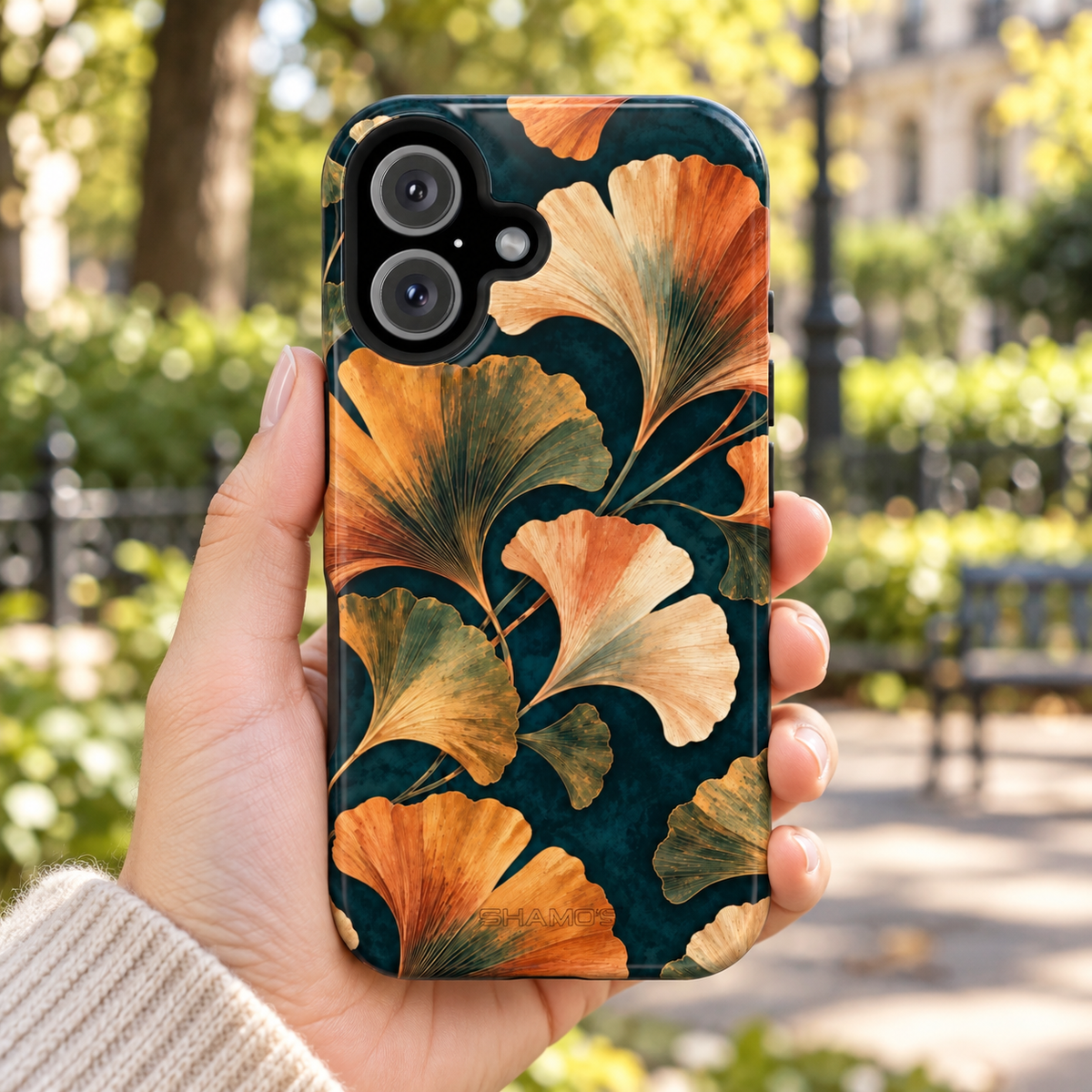 Adult woman holding the Nocturne Ginkgo iPhone 16 case outdoors #iphone-16