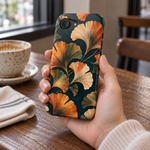 Adult woman holding the Nocturne Ginkgo iPhone 17e case at a cafe #iphone-17e
