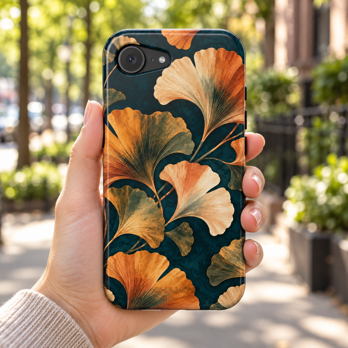 Adult woman holding the Nocturne Ginkgo iPhone 17e case outdoors #iphone-17e