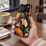 Adult woman holding the Nocturne Ginkgo iPhone 18 Pro case at a cafe #iphone-18-pro